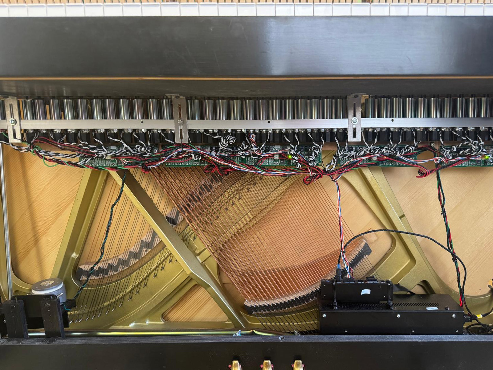 Close-up of a QRS player piano mechanism installed under the keys